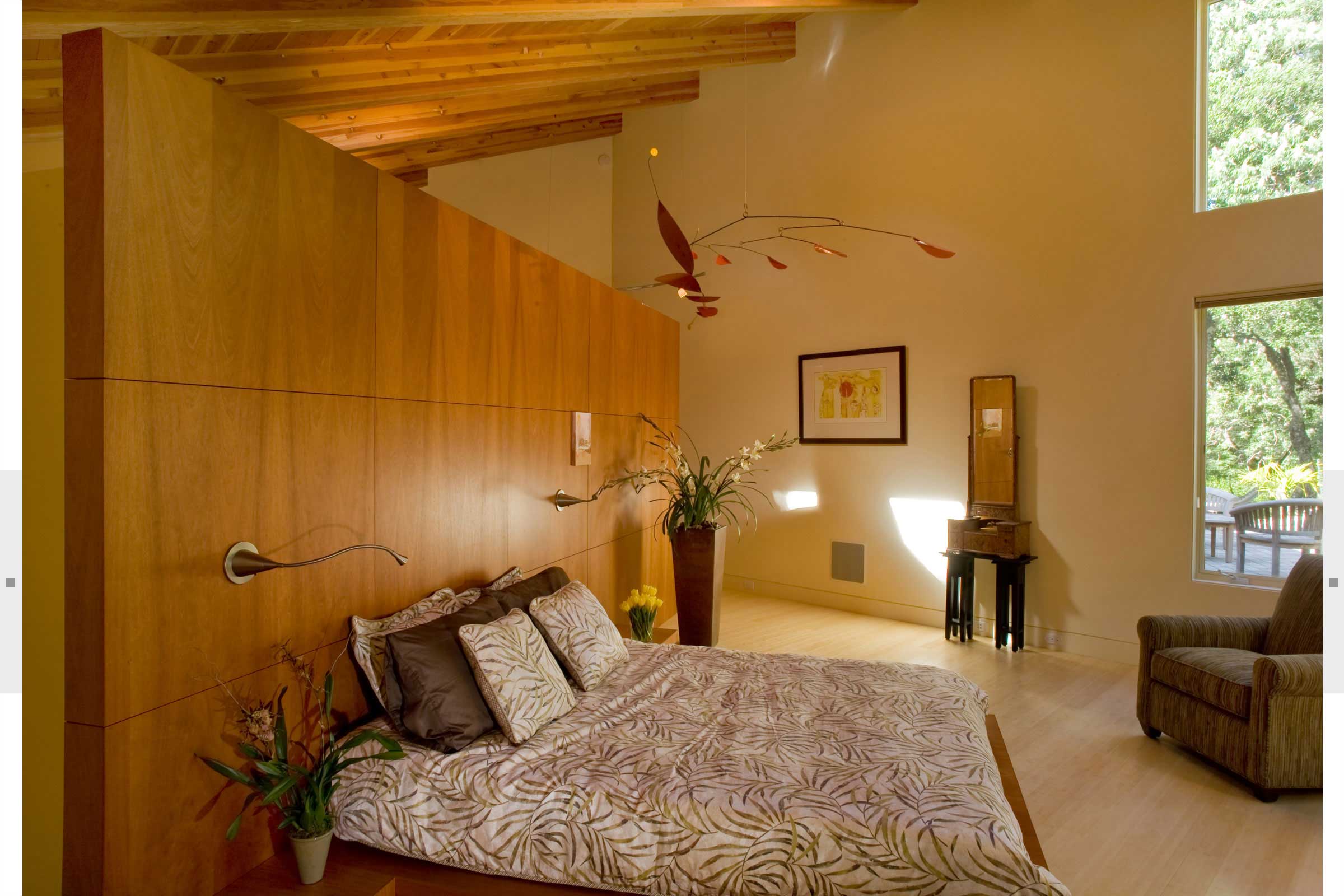 bedroom with large wood wall and expansive windows