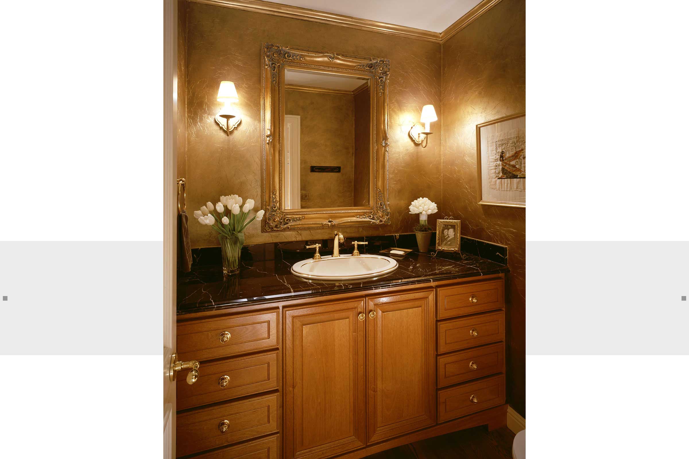 bathroom with custom cabinets and gold mirror