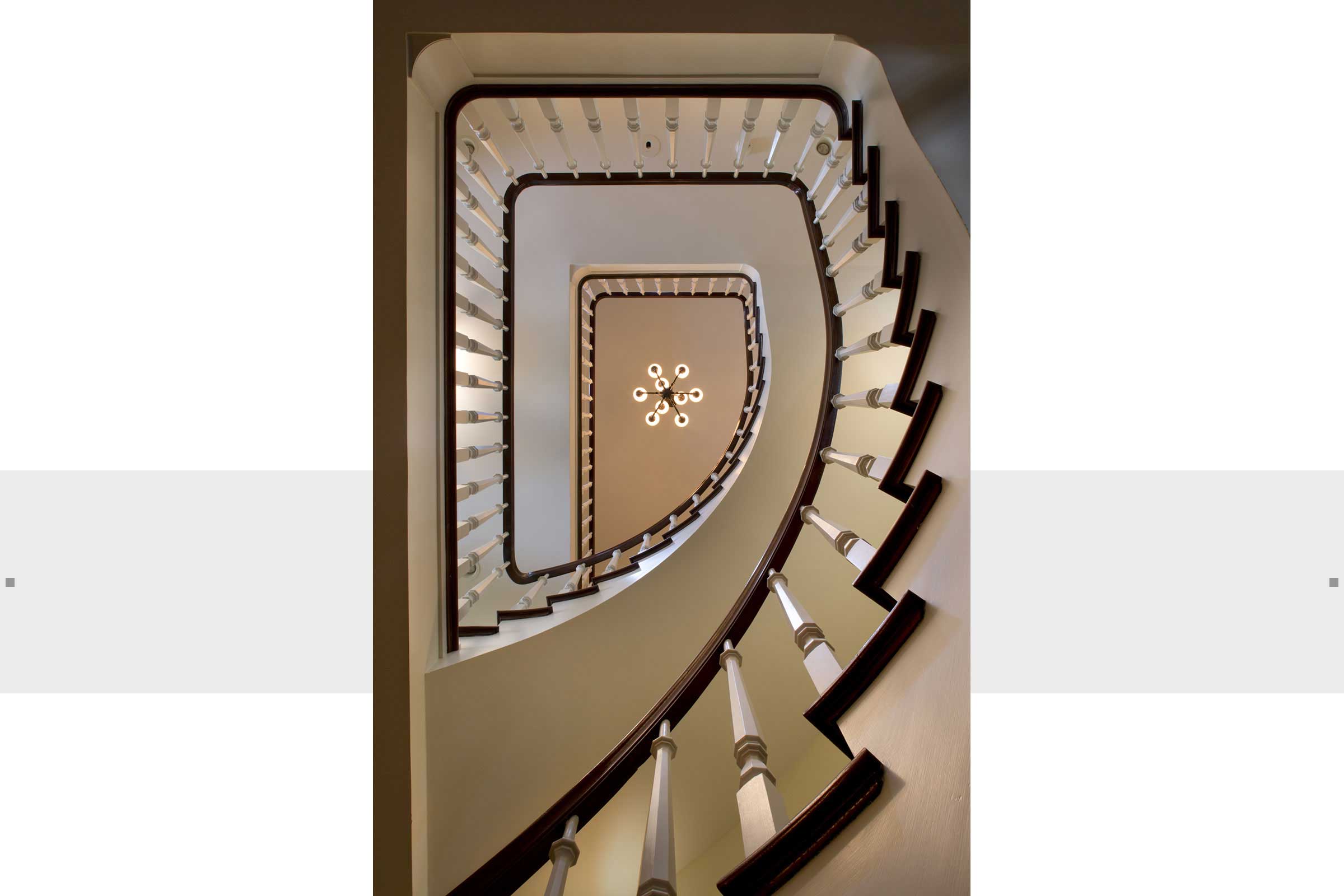staircase in large home with light fixture at top