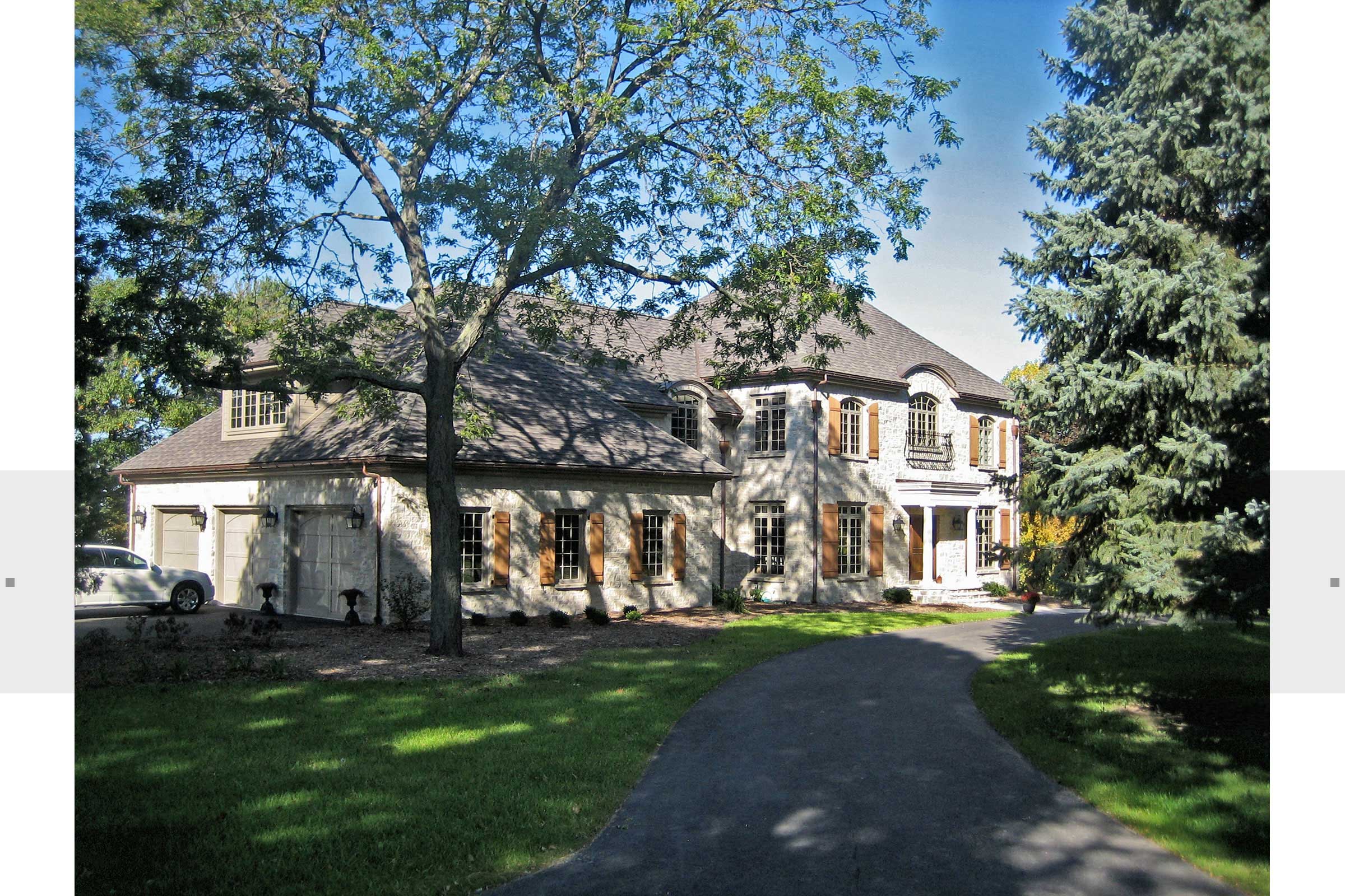 exterior view of large stone home with driveway